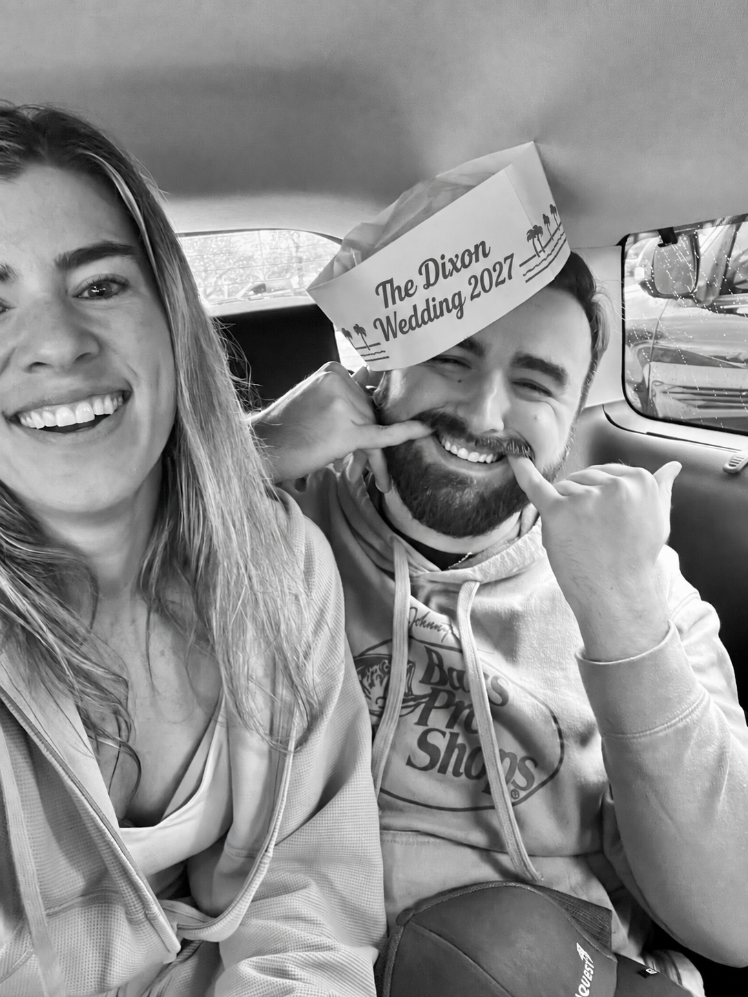 Ethan and Chloe smiling together in their The Dixon Wedding 2027 paper hat