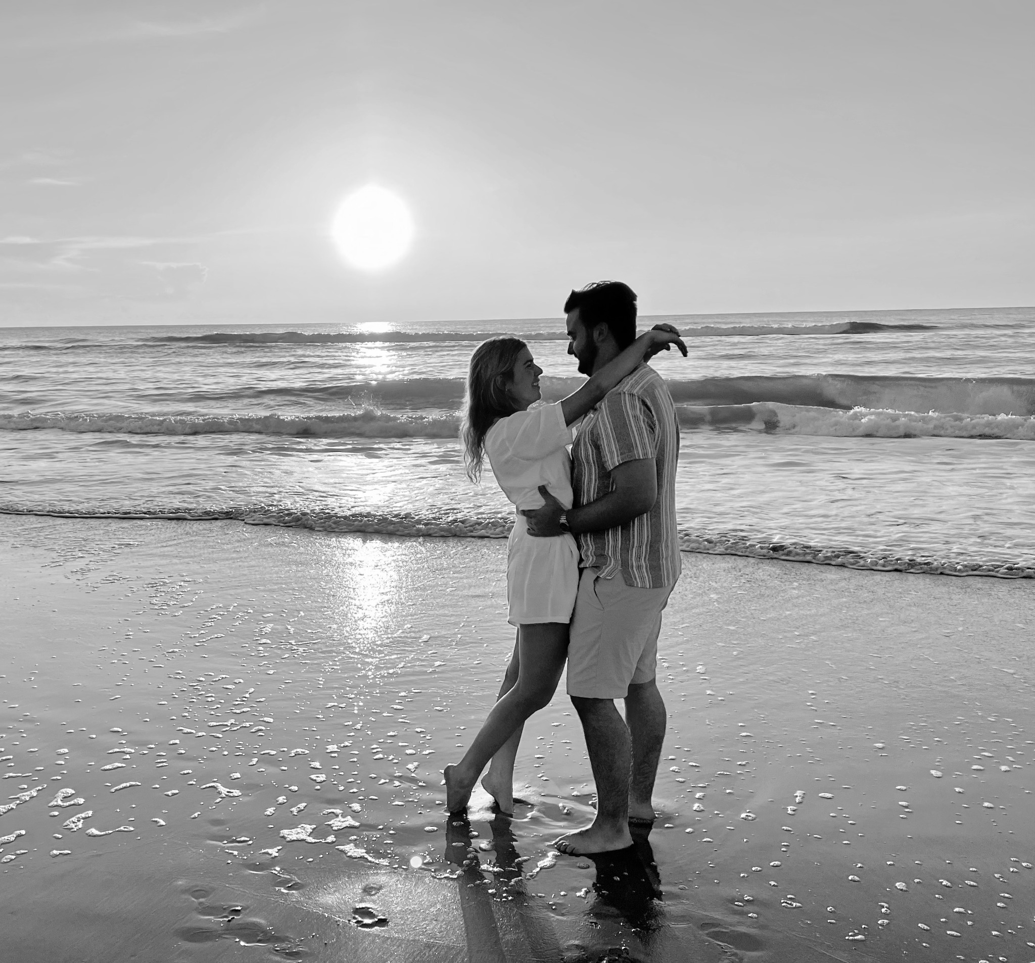 Ethan and Chloe embracing on the beach at sunset